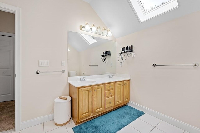 full bathroom featuring a skylight, vaulted ceiling, tile patterned floors, double vanity, and baseboards