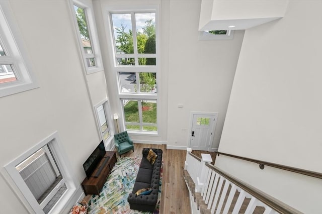 entryway featuring a towering ceiling, light wood-style floors, and baseboards