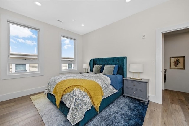 bedroom with wood finished floors, recessed lighting, and baseboards