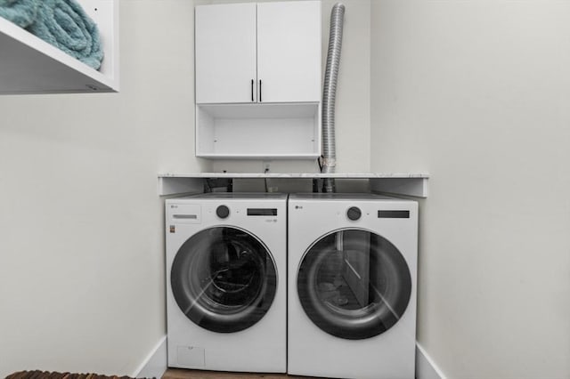 laundry room with washer and dryer, cabinet space, and baseboards