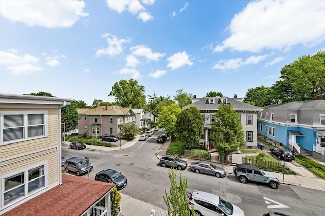 view of asphalt street with a residential view, sidewalks, and curbs