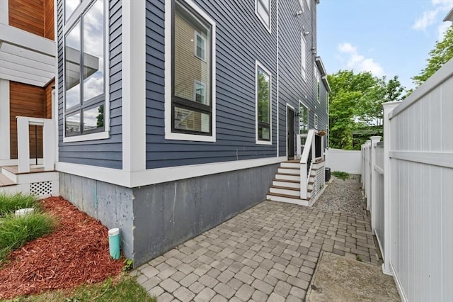 view of property exterior featuring fence and a patio area