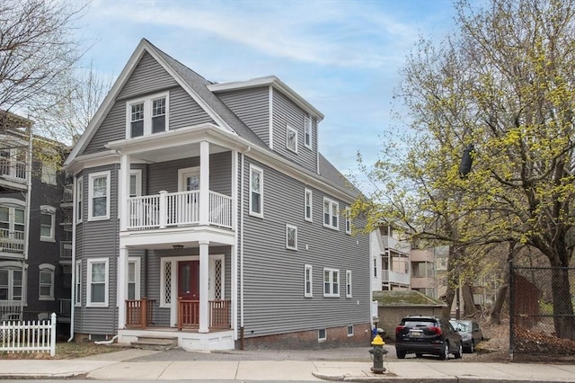 view of front of home featuring fence and a balcony