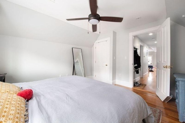 bedroom featuring ceiling fan, vaulted ceiling, and wood finished floors