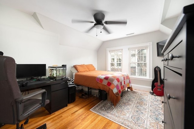 bedroom with a ceiling fan, visible vents, light wood-style flooring, and lofted ceiling