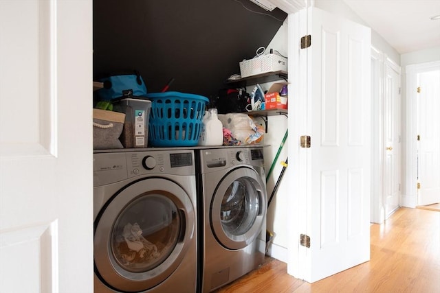 clothes washing area featuring laundry area, washer and dryer, and light wood-type flooring