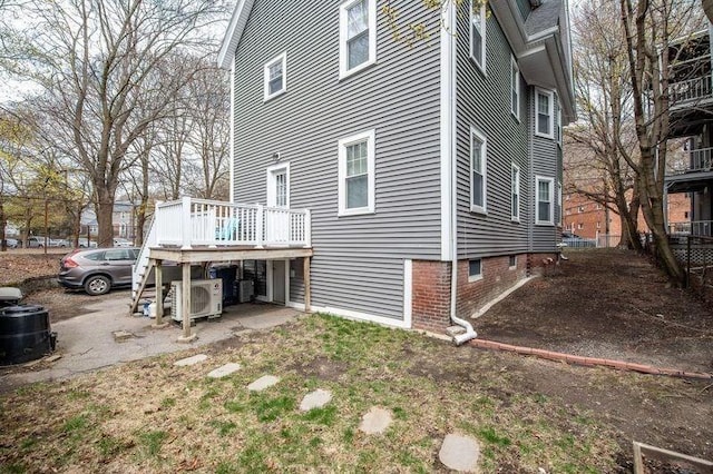 rear view of property with ac unit and a wooden deck