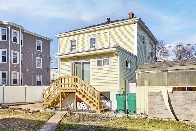 back of property featuring a chimney, stairs, and fence