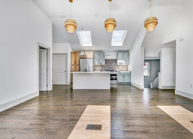 unfurnished living room with a skylight, dark hardwood / wood-style floors, and high vaulted ceiling