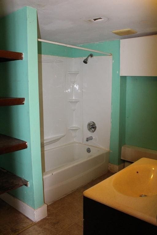 bathroom featuring tile patterned floors,  shower combination, and sink