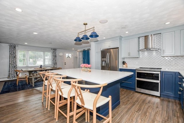 8 Highland View Ave, Mattapoisett, MA 02739 - kitchen with appliances with stainless steel finishes, wall chimney range hood, blue cabinets, dark wood-style flooring, and recessed lighting