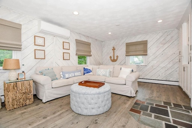 8 Highland View Ave, Mattapoisett, MA 02739 - living area featuring a baseboard heating unit, an AC wall unit, wood walls, wood finished floors, and plenty of natural light