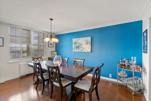 dining room featuring crown molding, dark wood-type flooring, and a chandelier