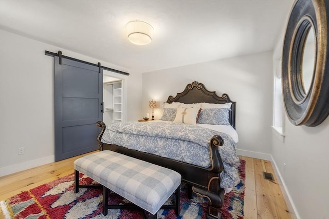 16 Walking Stick, Plymouth, MA 02360 - bedroom featuring a barn door, wood finished floors, and a spacious closet