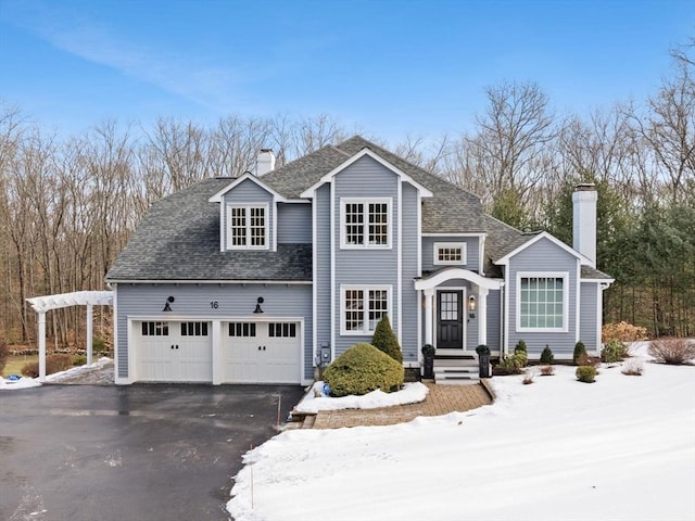 front facade with a garage and a pergola