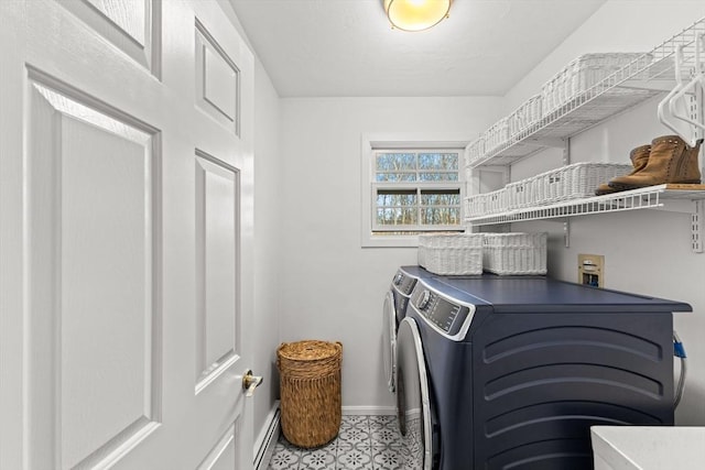 washroom with washing machine and clothes dryer and a baseboard heating unit