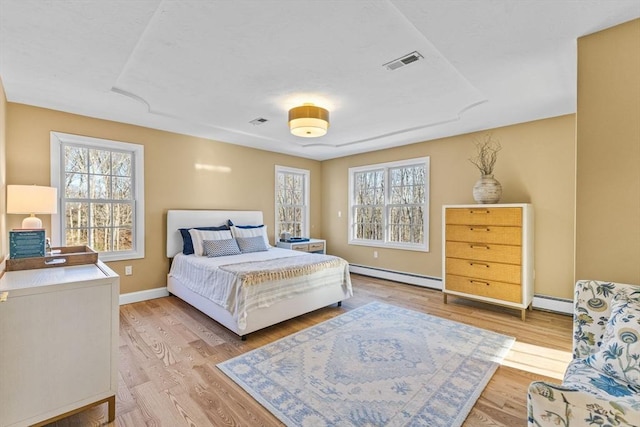 bedroom featuring light wood-type flooring and baseboard heating