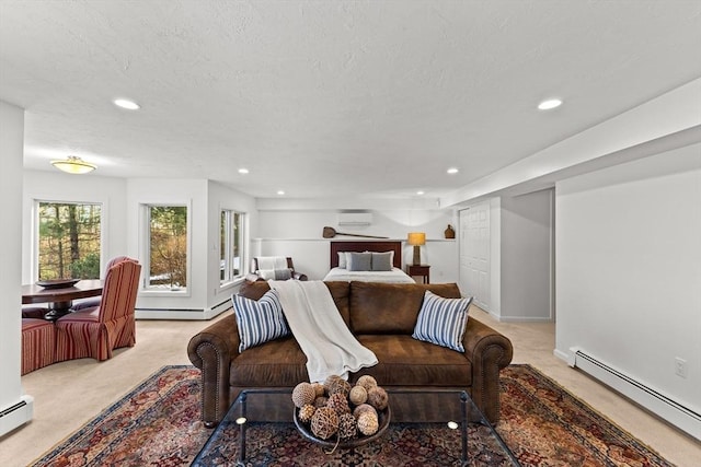 bedroom with light colored carpet, an AC wall unit, a textured ceiling, and a baseboard heating unit