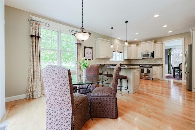 dining room featuring light wood-style floors, baseboards, and recessed lighting