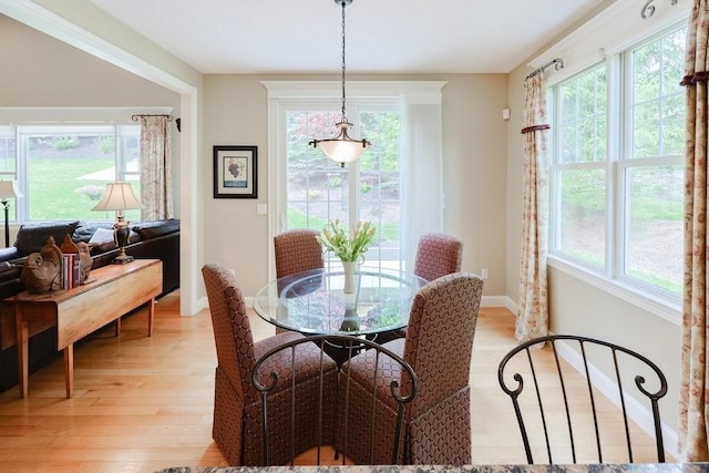 dining space featuring light wood finished floors and baseboards