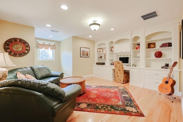 living room featuring light wood-type flooring, baseboards, and recessed lighting