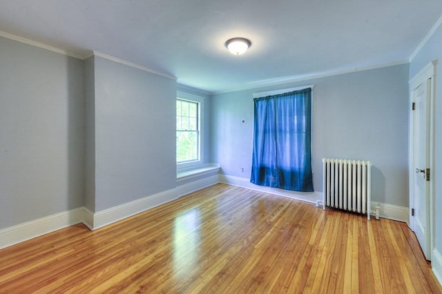 unfurnished room featuring crown molding, radiator, baseboards, and light wood finished floors