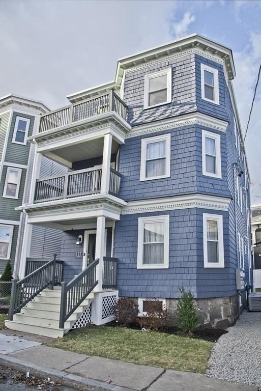 view of front of property featuring a balcony and central AC unit