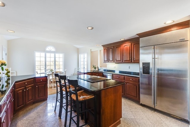 6 Snow Way, Orleans, MA 02653 - kitchen featuring appliances with stainless steel finishes, granite tiled floors, dark countertops, a breakfast bar, and recessed lighting