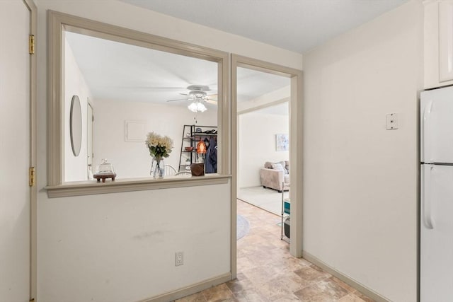 kitchen featuring ceiling fan, white fridge, and white cabinets