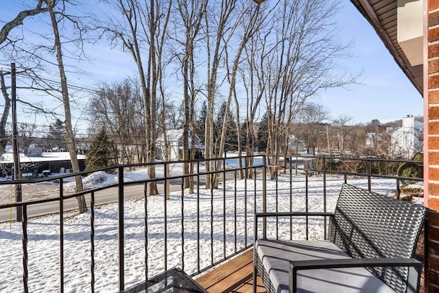 view of snow covered back of property