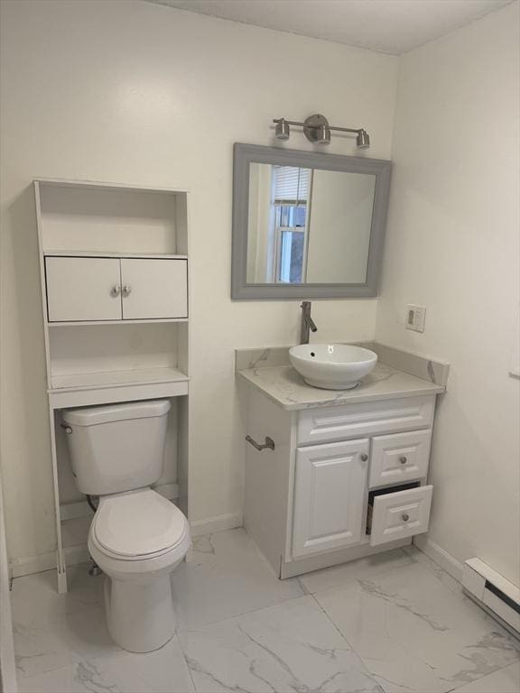 half bath featuring marble finish floor, a baseboard radiator, toilet, vanity, and baseboards