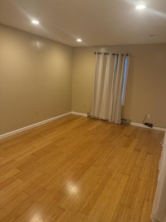 empty room featuring light wood-style floors, baseboards, and recessed lighting