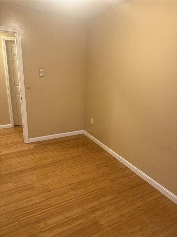 spare room with light wood finished floors and baseboards