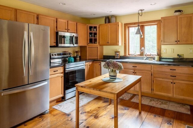 29 Miscoe Rd, Mendon, MA 01756 - kitchen featuring stainless steel appliances, dark countertops, light wood finished floors, pendant lighting, and glass insert cabinets