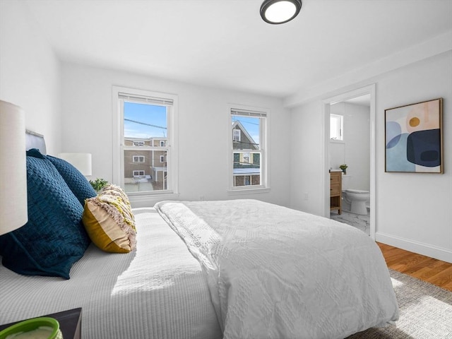 bedroom with hardwood / wood-style flooring and ensuite bath