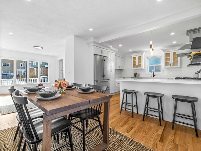 dining space featuring sink and light wood-type flooring