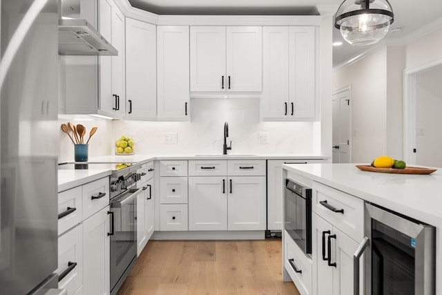 18 Franklin Unit 202, Salem, MA 01970 - kitchen featuring beverage cooler, stainless steel range with electric stovetop, freestanding refrigerator, a sink, and wall chimney exhaust hood