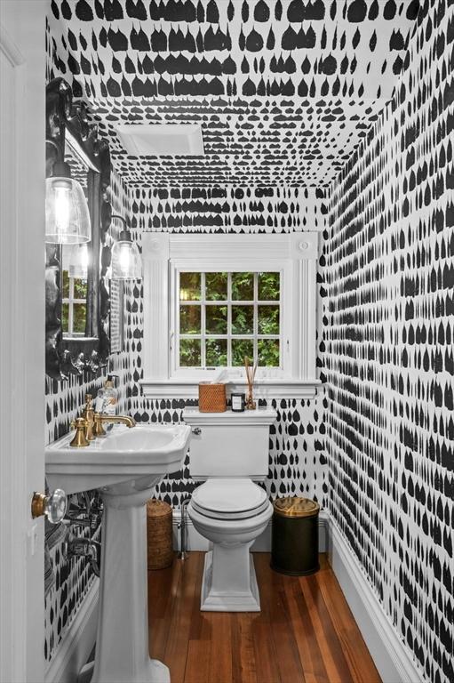half bath with toilet and wood finished floors