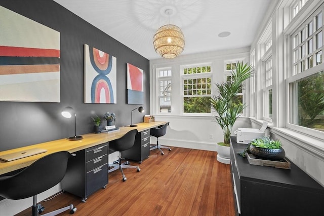 home office featuring a chandelier, baseboards, and wood finished floors