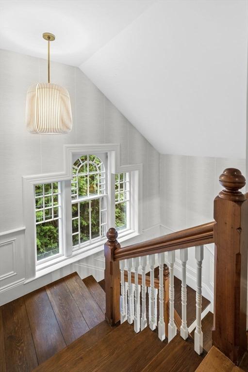 stairs featuring vaulted ceiling and wood finished floors