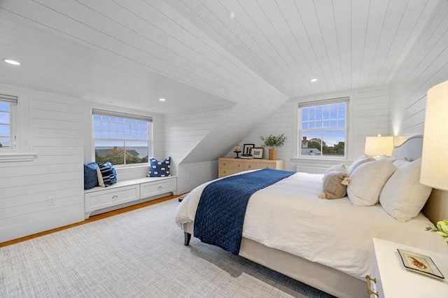 bedroom with vaulted ceiling, wood walls, wood ceiling, and multiple windows
