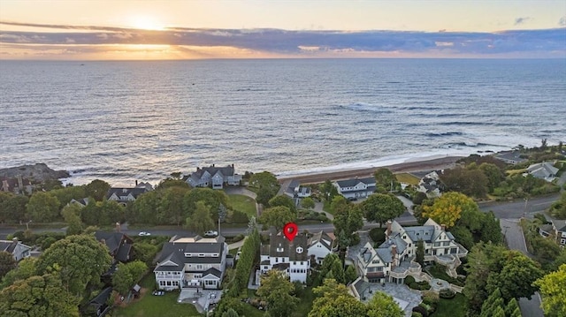 aerial view at dusk with a water view and a residential view