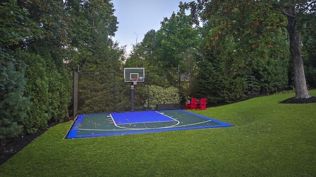 view of basketball court featuring a lawn and basketball hoop