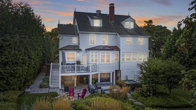 rear view of house with a deck, a patio, stairway, a chimney, and outdoor lounge area