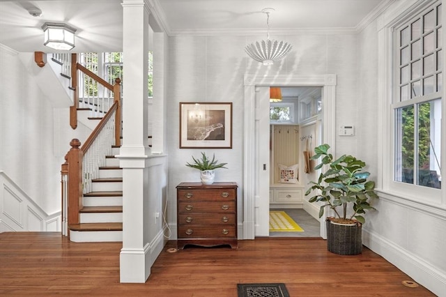 hallway featuring stairs, a healthy amount of sunlight, visible vents, and wood finished floors