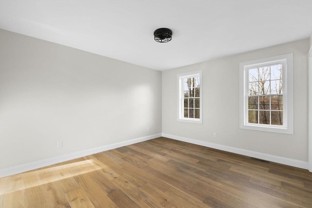 unfurnished room with hardwood / wood-style flooring