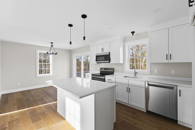 kitchen with a kitchen island, white cabinetry, sink, and appliances with stainless steel finishes