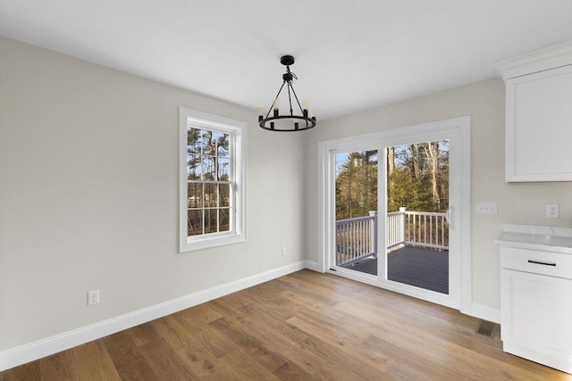 unfurnished dining area with light hardwood / wood-style flooring and an inviting chandelier