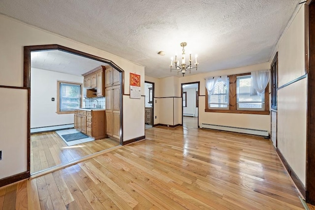 2 Hammond Ct, Quincy, MA 02169 - unfurnished dining area with baseboard heating, a chandelier, light wood finished floors, a textured ceiling, and healthy amount of natural light