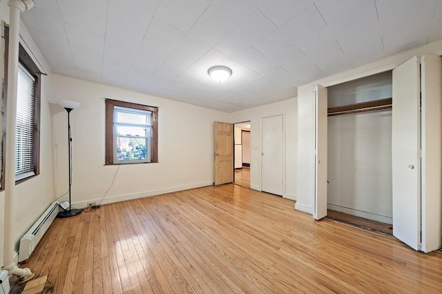 2 Hammond Ct, Quincy, MA 02169 - unfurnished bedroom with a baseboard radiator, light wood-style floors, baseboards, and a closet
